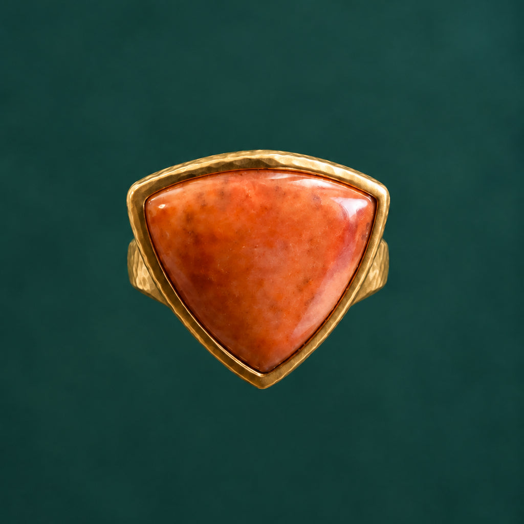 Front view of the triangular orange cabochon ring on a mandrel