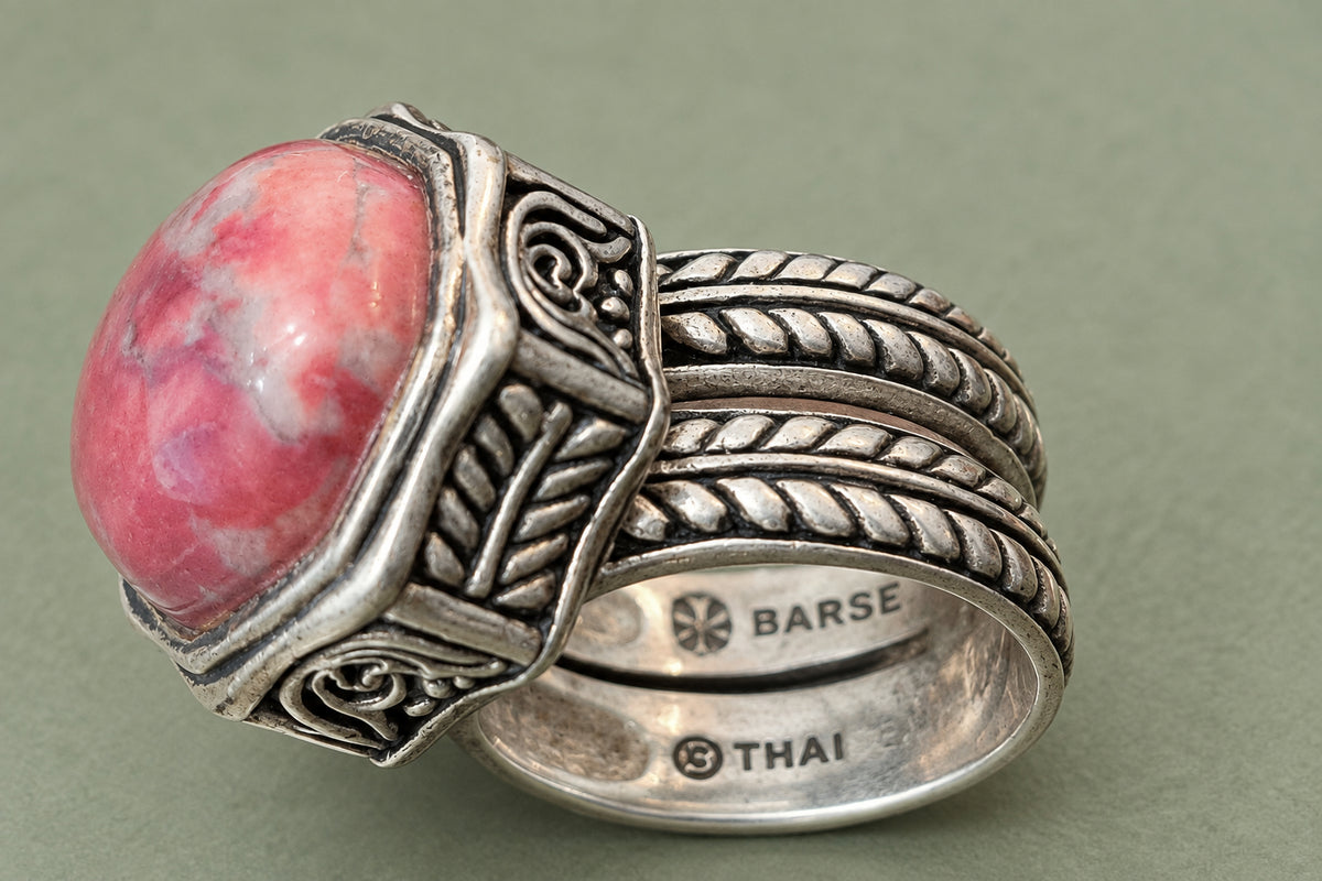 Side view of pink rhodonite cabochon and ornate multi-row silver band