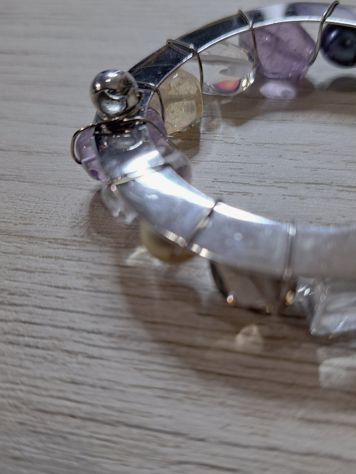 Close-up of reverse attachment hardware and wire-wrapped elements on circular jewelry piece