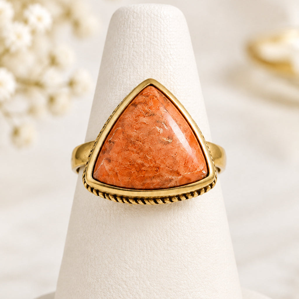 Barse ring with triangular peach-orange cabochon and gold-tone rope-detail setting