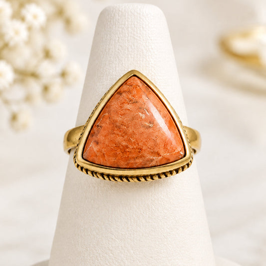 Barse ring with triangular peach-orange cabochon and gold-tone rope-detail setting