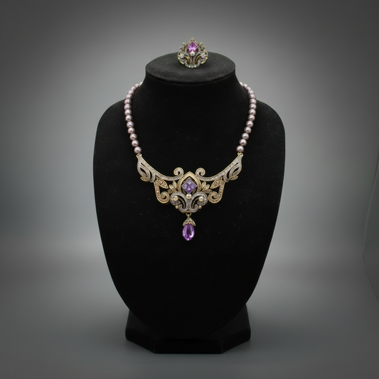Heidi Daus lavender bead scrollwork necklace with purple center stone and amber-tone drop on a black display